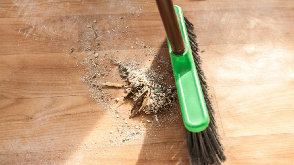 a picture of a broom sweeping dust on the floor