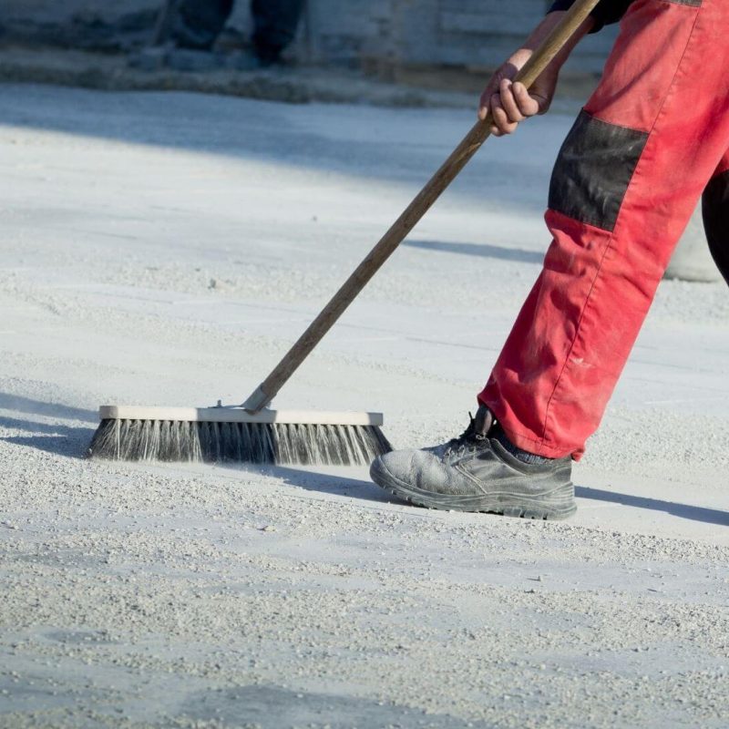 a man sweeping a dusty floor